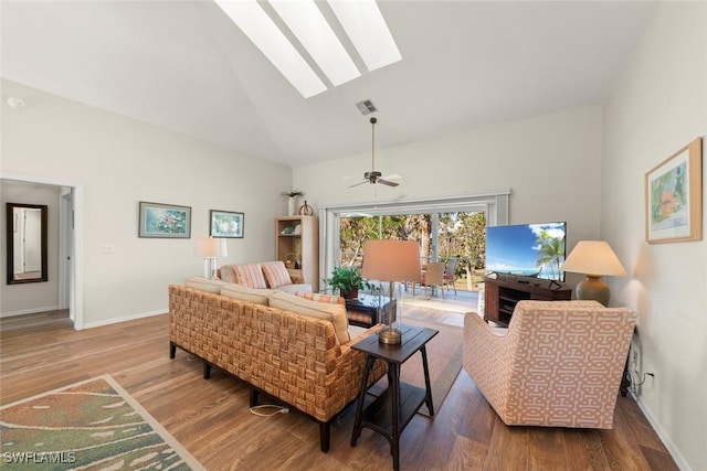 living room with wood-type flooring, ceiling fan, high vaulted ceiling, and a skylight