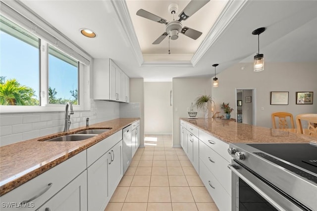 kitchen featuring sink, white cabinetry, decorative light fixtures, appliances with stainless steel finishes, and a raised ceiling