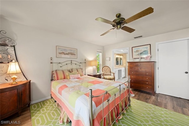 bedroom with ceiling fan, connected bathroom, and dark hardwood / wood-style flooring