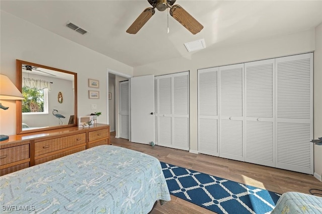 bedroom featuring multiple closets, ceiling fan, and light hardwood / wood-style flooring