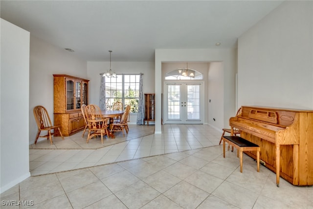 tiled dining room with an inviting chandelier and french doors