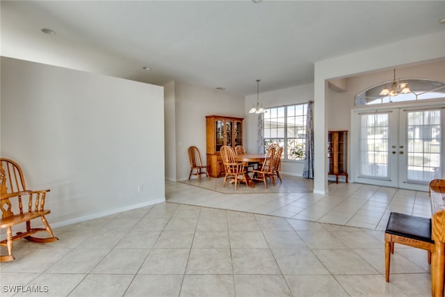 foyer entrance with light tile patterned floors, an inviting chandelier, and french doors