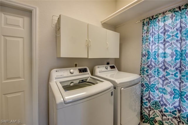 laundry room featuring cabinets and separate washer and dryer