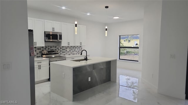 kitchen with decorative backsplash, appliances with stainless steel finishes, a sink, white cabinets, and marble finish floor