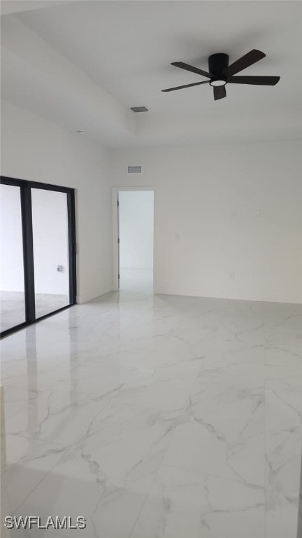 unfurnished room featuring a ceiling fan, visible vents, and marble finish floor