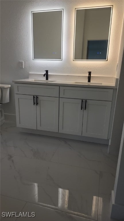 bathroom with double vanity, a sink, and marble finish floor