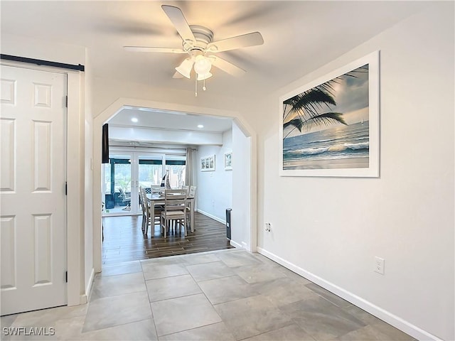 unfurnished dining area featuring light tile patterned floors and ceiling fan