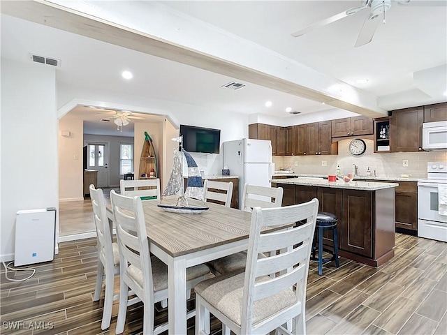 dining area featuring ceiling fan and beam ceiling