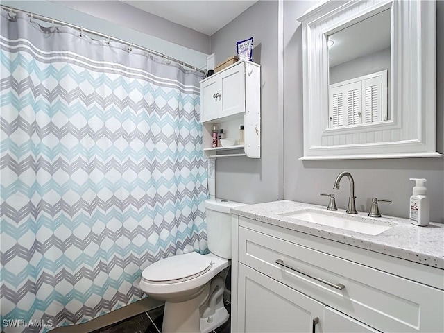 bathroom featuring vanity, toilet, and walk in shower