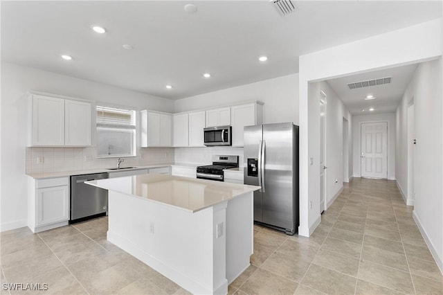 kitchen featuring sink, a center island, white cabinets, and appliances with stainless steel finishes