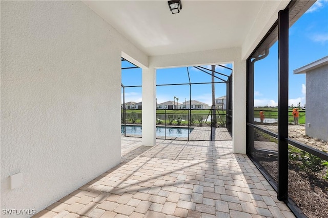 unfurnished sunroom featuring a water view and a wealth of natural light