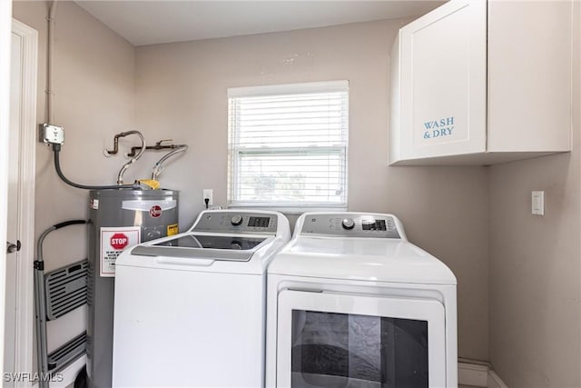 clothes washing area with cabinets, water heater, and independent washer and dryer