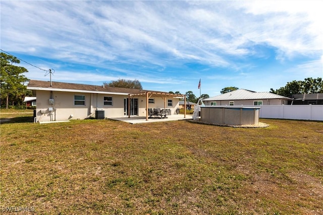 back of house with a fenced in pool, a patio, central AC unit, and a lawn