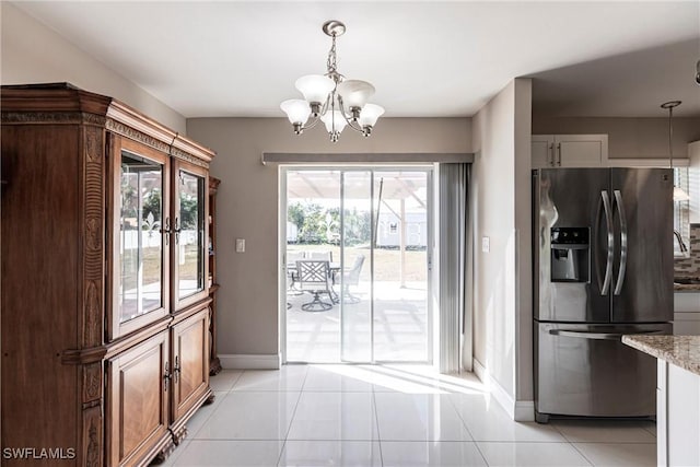 kitchen featuring pendant lighting, white cabinetry, stainless steel fridge, and light tile patterned flooring