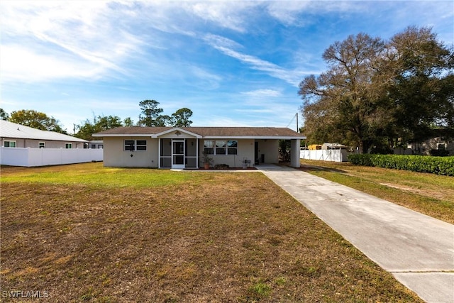 ranch-style house with a front lawn, a carport, and a sunroom