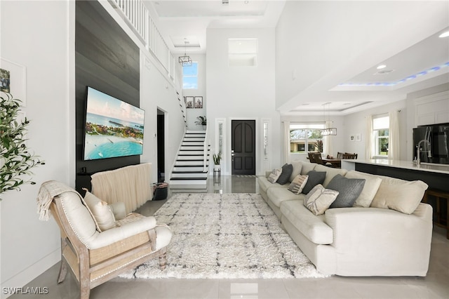 living room featuring a tray ceiling and a high ceiling