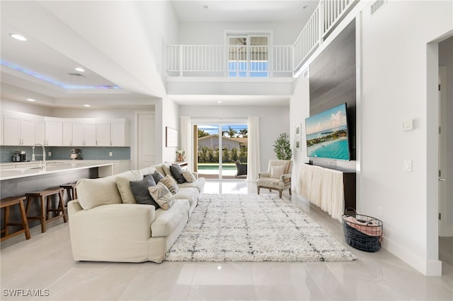 living room with a towering ceiling and sink