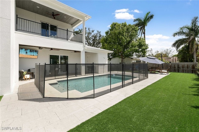 view of pool with a patio area, ceiling fan, and a lawn