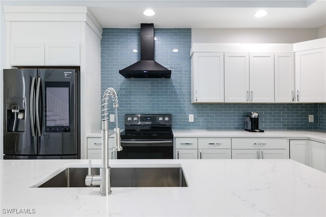 kitchen with stainless steel refrigerator with ice dispenser, wall chimney range hood, white cabinets, and black range with electric cooktop