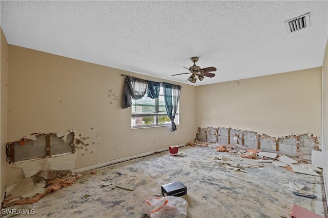 empty room with ceiling fan and a textured ceiling