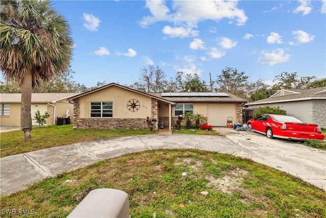 single story home with a front yard and solar panels