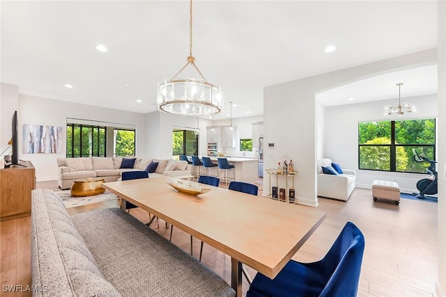 dining area featuring an inviting chandelier and light hardwood / wood-style flooring