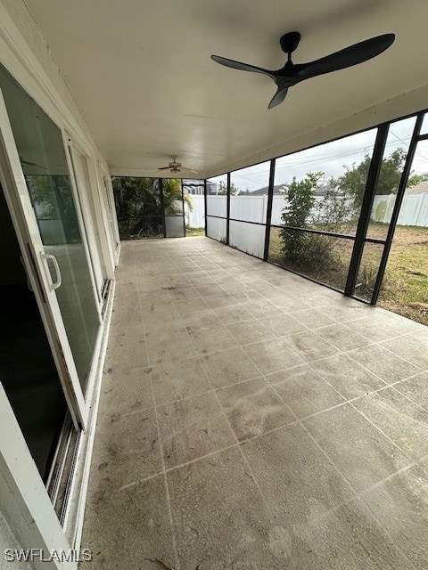 unfurnished sunroom featuring ceiling fan