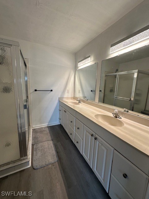 bathroom with a shower with door, wood-type flooring, and vanity