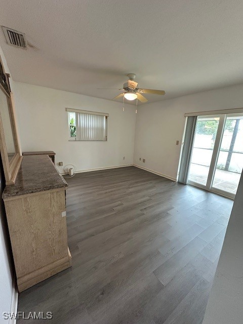 unfurnished room with dark hardwood / wood-style flooring, a textured ceiling, and ceiling fan