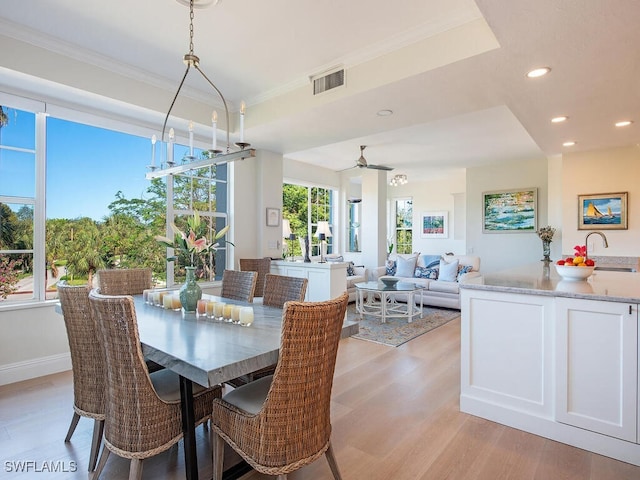 dining area featuring crown molding, ceiling fan, and light hardwood / wood-style flooring