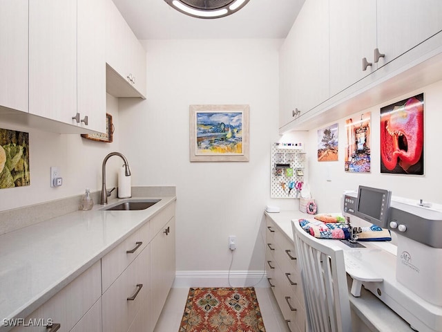 kitchen with white cabinetry, sink, and light tile patterned floors