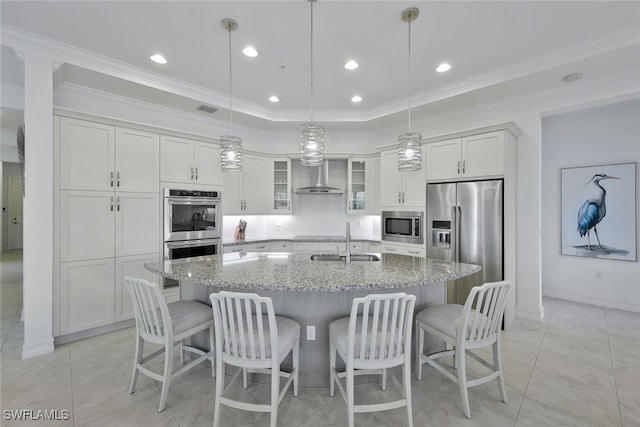 kitchen featuring stainless steel appliances, sink, pendant lighting, and a kitchen island with sink