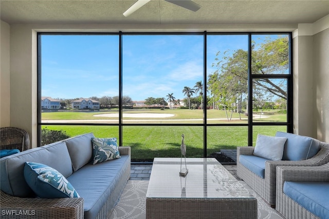 sunroom / solarium featuring a healthy amount of sunlight and ceiling fan