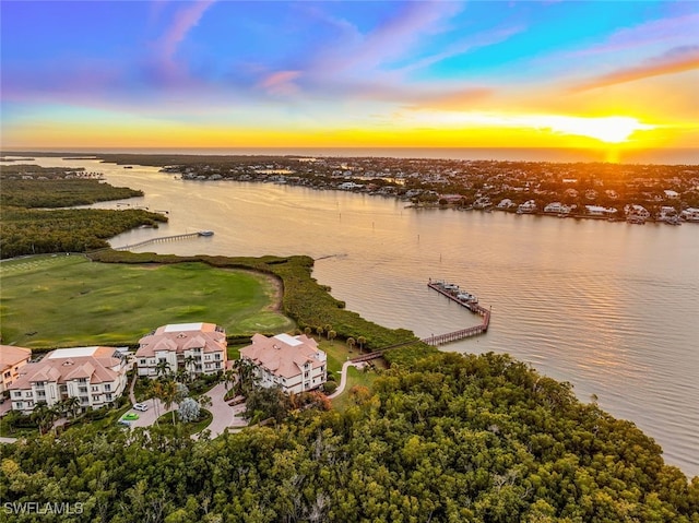 aerial view at dusk featuring a water view