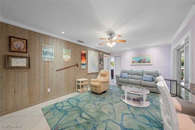 tiled living room with wooden walls, ornamental molding, and ceiling fan