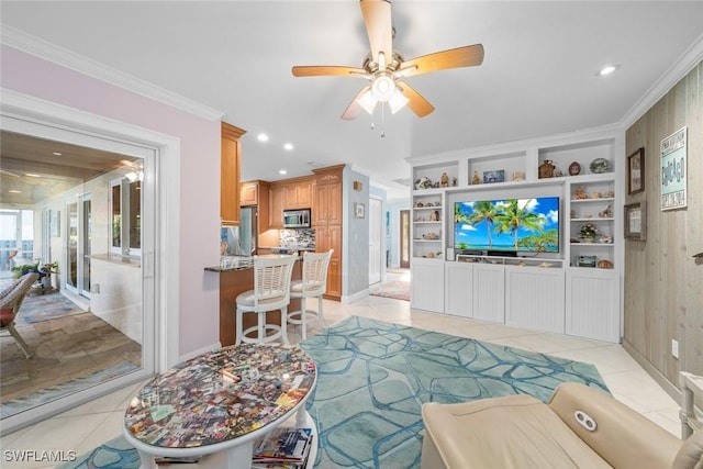 living room with crown molding, light tile patterned floors, ceiling fan, and built in shelves