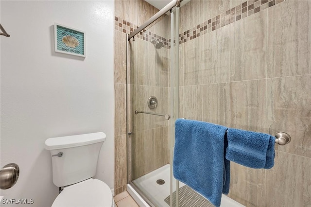 bathroom with a shower with shower door and toilet