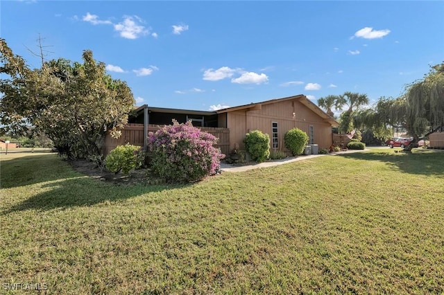 view of side of property with a lawn and central air condition unit