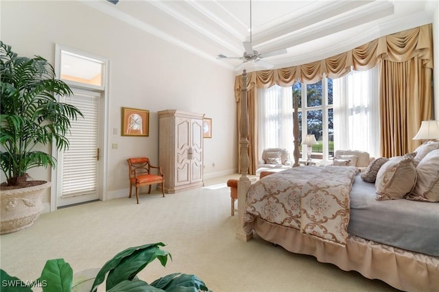 carpeted bedroom with access to exterior, a tray ceiling, ornamental molding, and ceiling fan