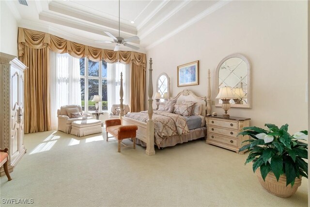 bedroom featuring a raised ceiling, ornamental molding, carpet, and ceiling fan