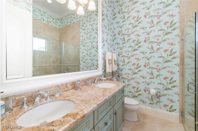 bathroom featuring vanity, toilet, a shower with door, crown molding, and tile patterned floors