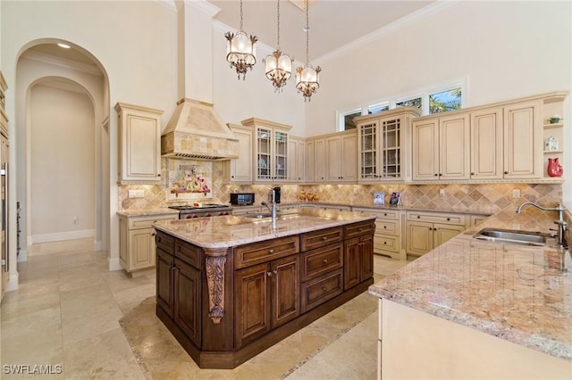 kitchen with dark brown cabinetry, sink, cream cabinets, and hanging light fixtures