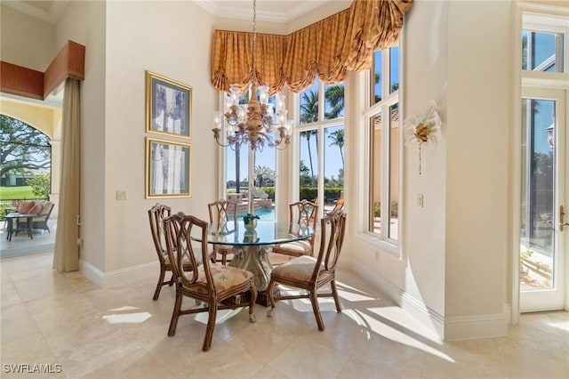 dining room with an inviting chandelier, a towering ceiling, crown molding, and a wealth of natural light