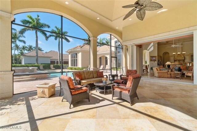 view of patio / terrace featuring an outdoor hangout area, ceiling fan, and glass enclosure