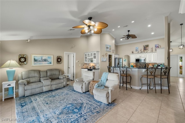 tiled living room featuring ornamental molding, ceiling fan, and high vaulted ceiling