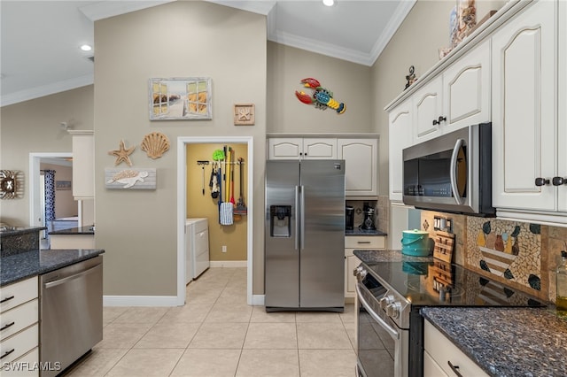 kitchen featuring appliances with stainless steel finishes, dark stone countertops, white cabinets, independent washer and dryer, and crown molding