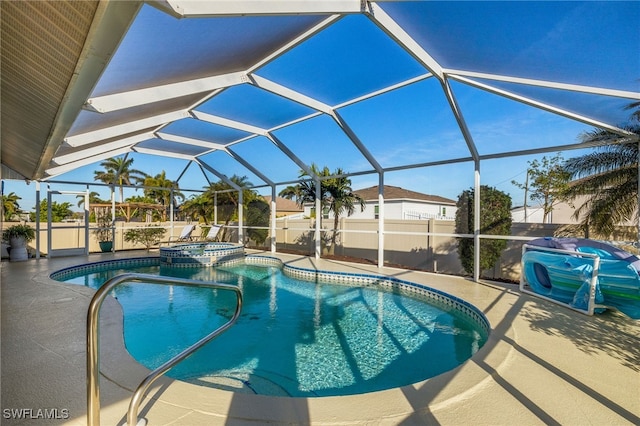 view of pool featuring a patio, an in ground hot tub, and glass enclosure