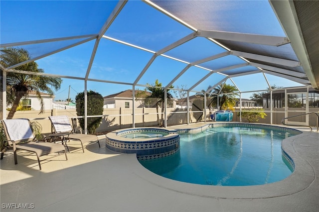 view of pool with an in ground hot tub, glass enclosure, and a patio