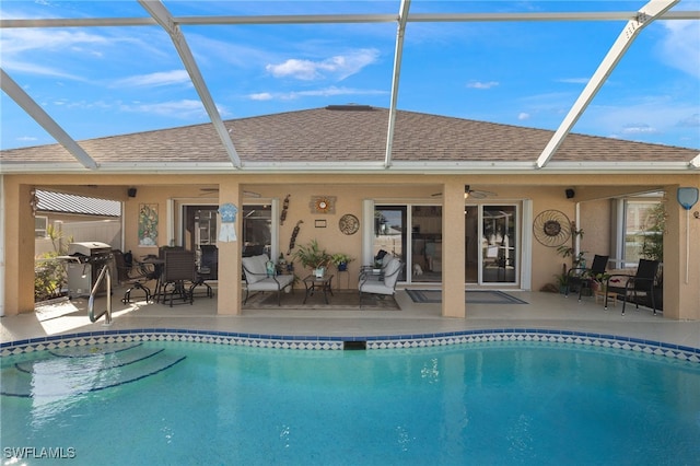 view of pool featuring a patio area, ceiling fan, and glass enclosure