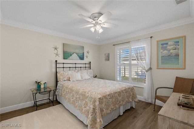 bedroom featuring hardwood / wood-style floors, crown molding, and ceiling fan